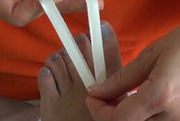 Zuerst wird ein ca. 10 cm langes Stück Tape längs v-förmig eingerissen. Die Basis des V wird am Fußrücken festgeklebt, die beiden 1 cm breiten Schenkel werden zur Fußsohle geführt.
